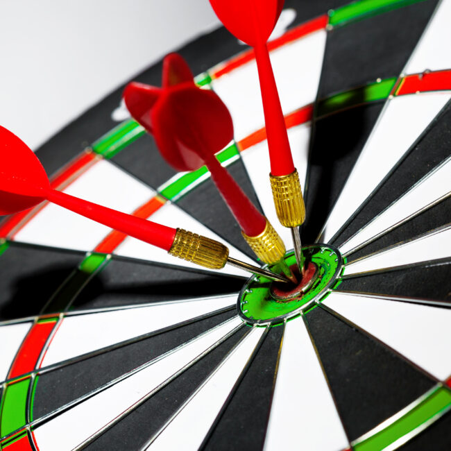 „Gra w darta – zawodnik celuje rzutką w tarczę turniejową”